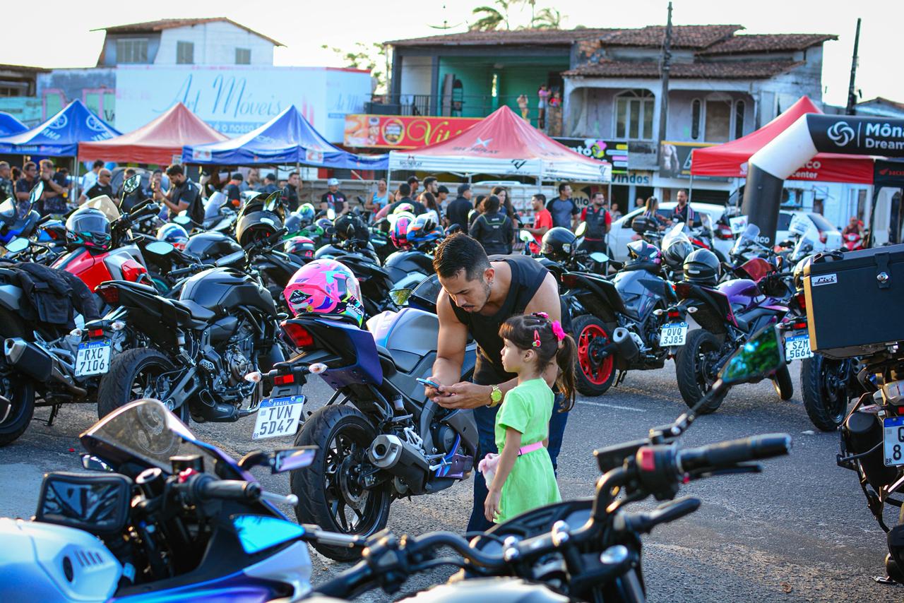 Pai e filha observando as motos expostas no evento